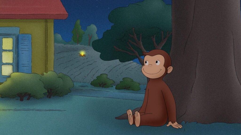Curious George sitting under a tree during the eclipse