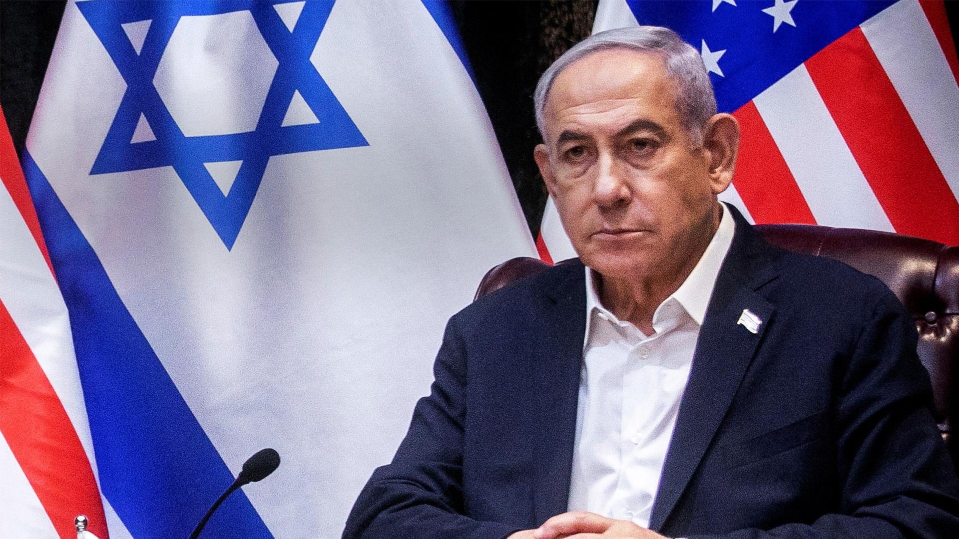 A photo of Benjamin Netanyahu - an older white male with short gray hair wearing a dark sports jacket and white collared shirt