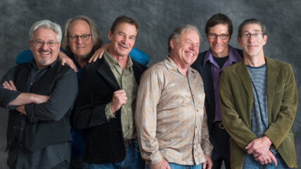 Six white males representing the band "Watkins and the Rapiers" stand together smiling at the camera.
