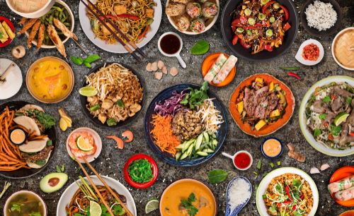 A aerial shot of a bunch of Asian dishes set on a Black counter