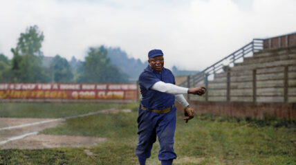 Baseball player Rube Foster throwing a baseball on a baseball field.