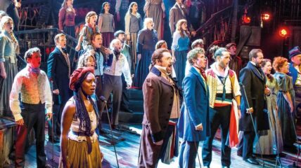 The cast of Les Misérables on stage performing