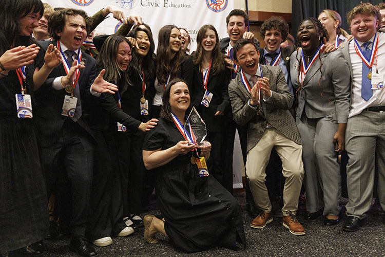 A group of students wearing medals around their necks cheering.