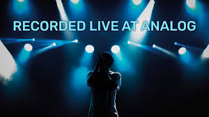 A silhouette of a person on stage singing with blue type above the reads: RECORDED LIVE AT ANALOG