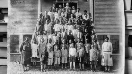 Segregation Scholarships-Black and White photo of black children and teachers outside a school building posing for a photo