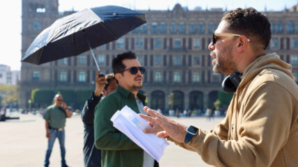 Director Ben DeJesus and host John Leguizamo on the set