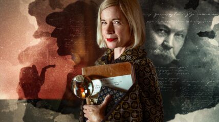 Lucy Worsley holding a book and magnifying glass.