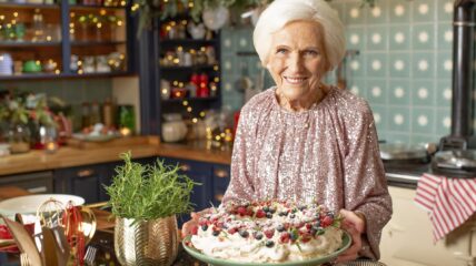 Mary Berry standing in a kitchen holding a pie