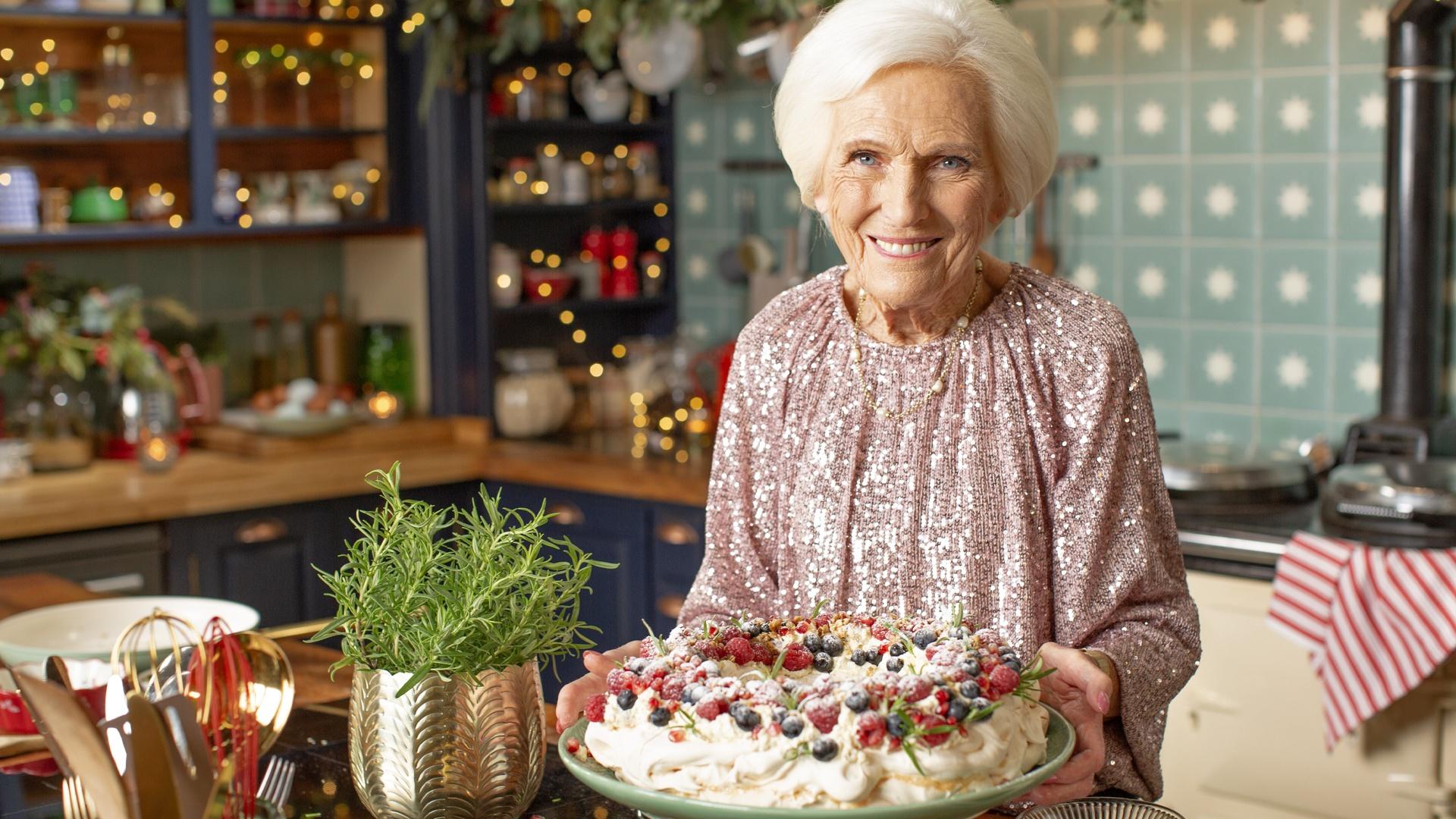 Mary Berry standing in a kitchen holding a pie