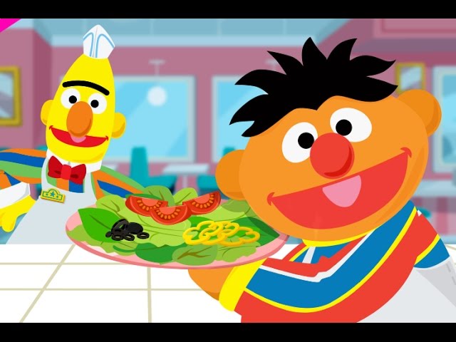 Burt is wearing an apron and Ernie is carrying a salad to be served in the Super Salad Diner game