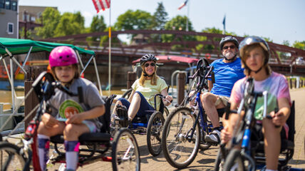 A family riding adaptive bikes on the canal