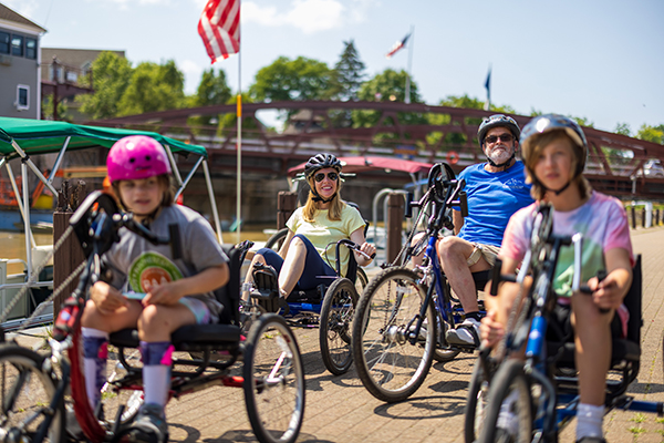 A family riding adaptive bikes on the canal