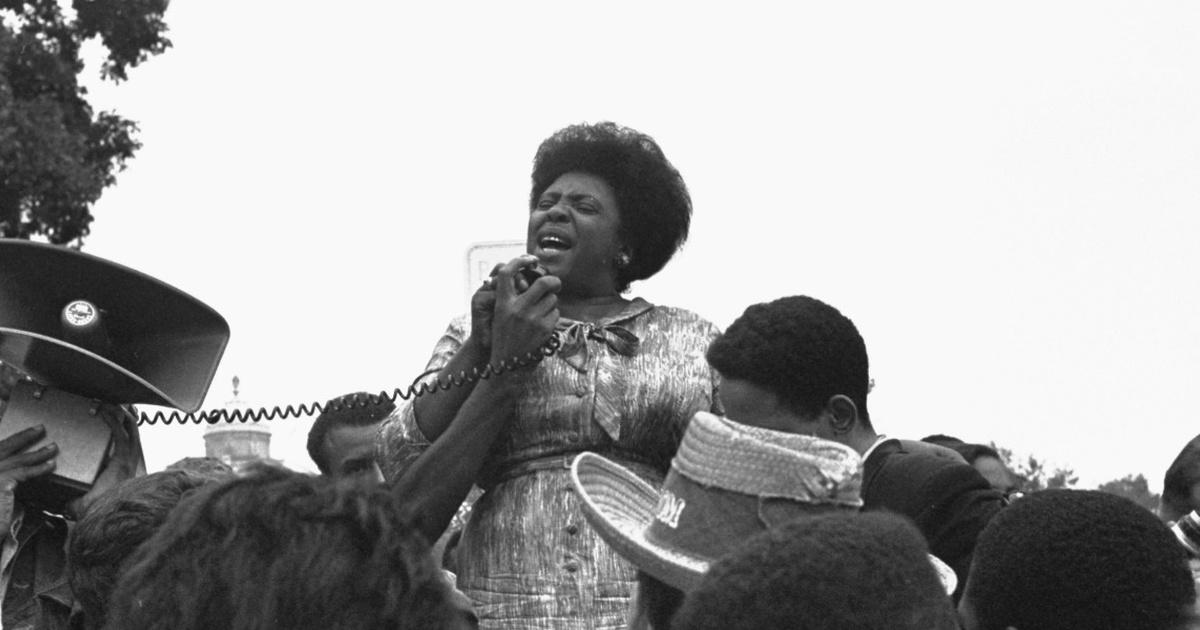 Activist Fannie Lou Hamer speaking into a mic as she addresses an audience.