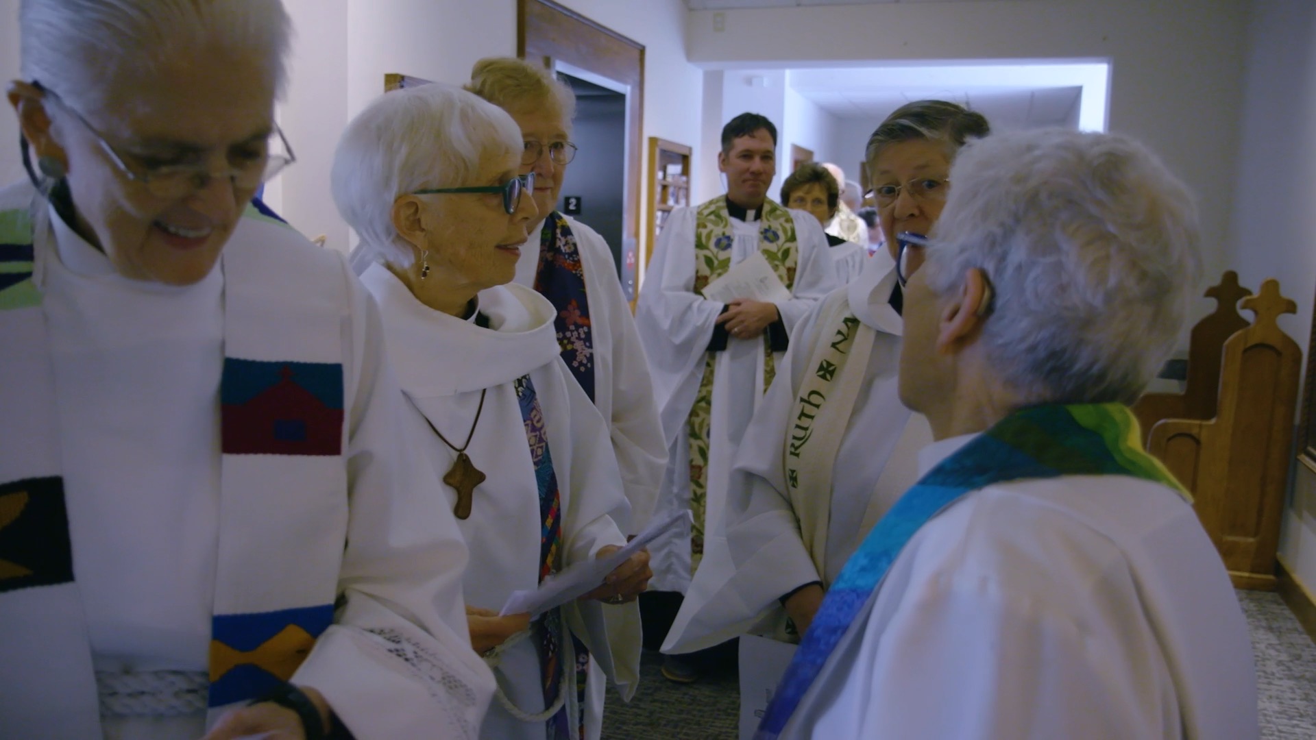 A group of female priests stand in a cirlce